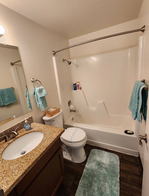 A bathroom with a white toilet, sink, and bathtub.