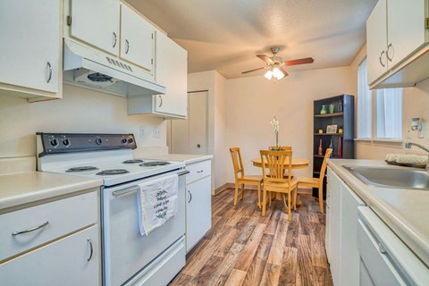 a kitchen with white appliances and a dining room table