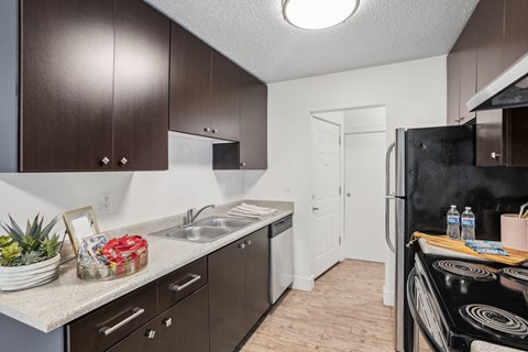 A kitchen with brown cabinets and a black stove top.