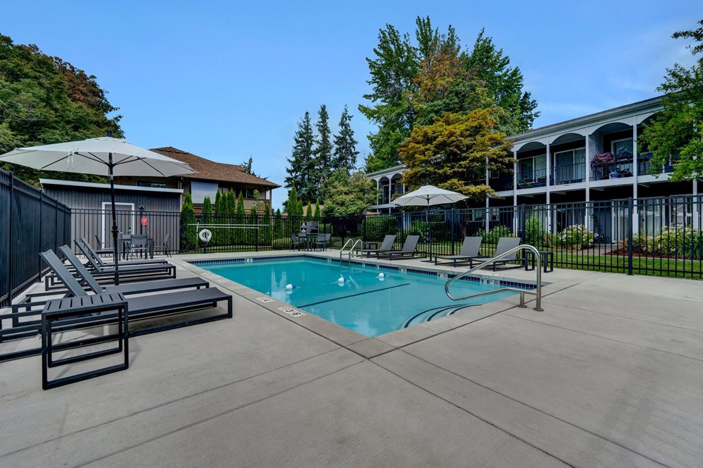 a swimming pool with lounge chairs and umbrellas in front of a building Sunset Station Apartments Portland Oregon a swimming pool with lounge chairs and umbrellas in front of a building Sunset Station Apartments Portland Oregon