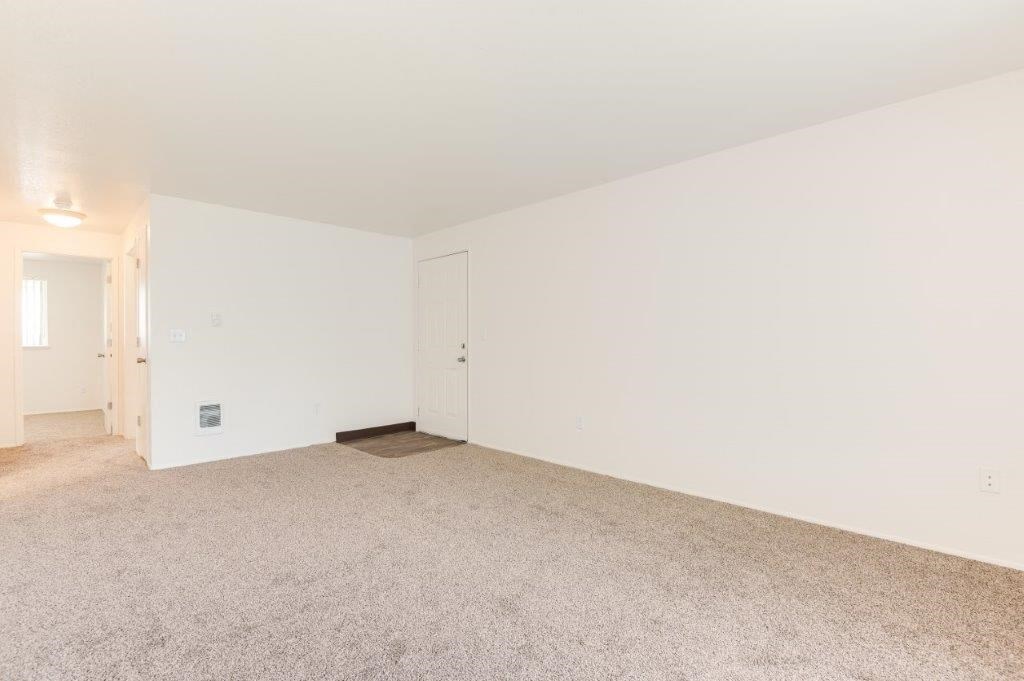 a bedroom with white walls and carpet