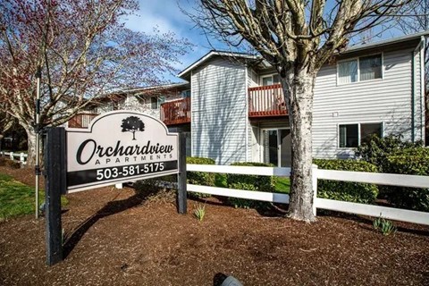A sign for Orchardview Apartments stands in front of a building.