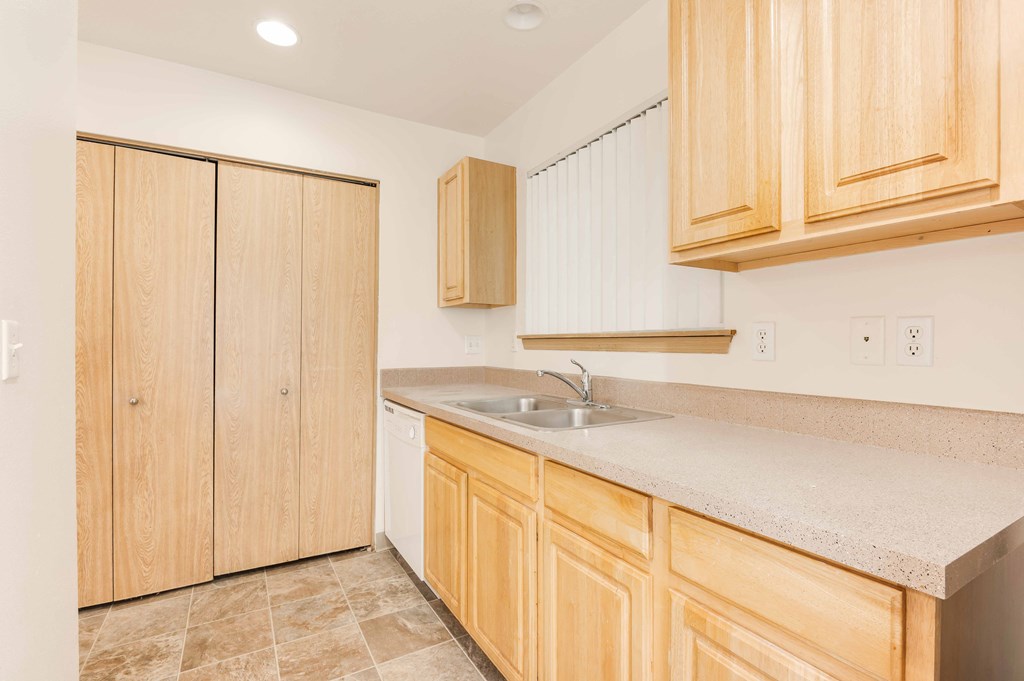 a kitchen with wooden cabinets and a stainless steel sink