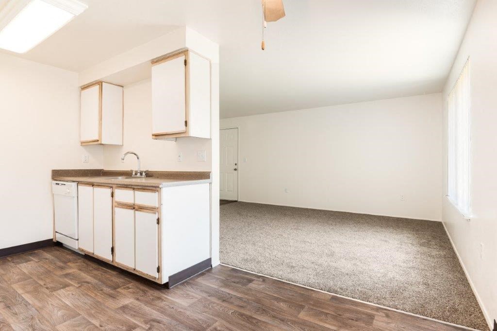 a kitchen and an empty living room in a house