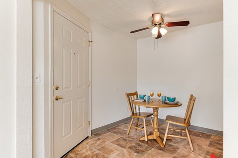 A dining room with a table set for two.
