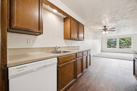 A kitchen with wooden cabinets and a white dishwasher.