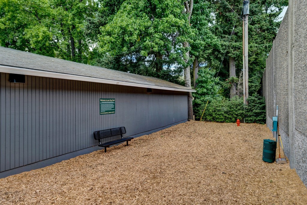 a bench sits in front of a building with trees in the background Sunset Station Apartments Portland Oregon 