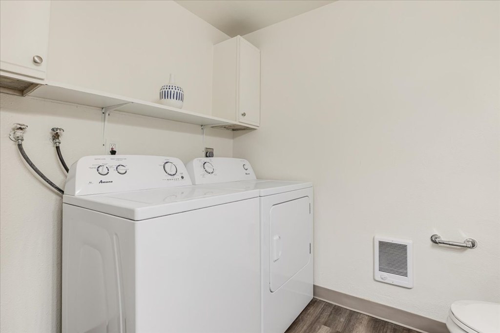 A white washing machine and dryer in a small laundry room.
