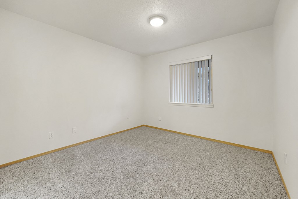 a bedroom with white walls and carpet