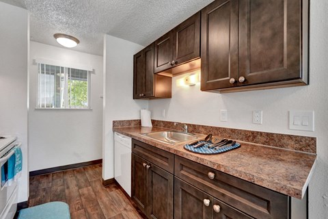 A kitchen with brown cabinets and a marble countertop.