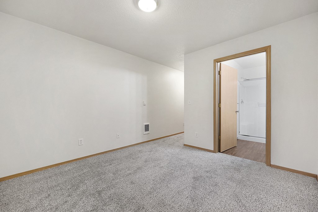 a bedroom with white walls and a carpeted floor