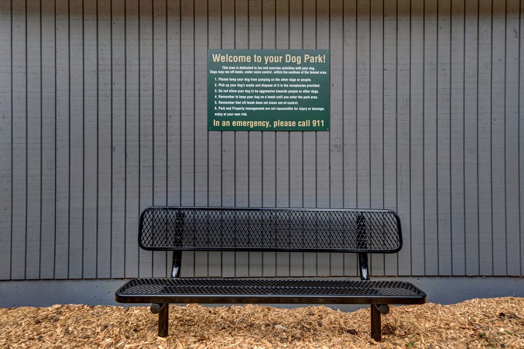 a bench in front of a wall with a sign on it Sunset Station Apartments Portland Oregon 