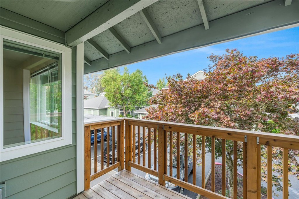 A wooden balcony with a trees in the distance