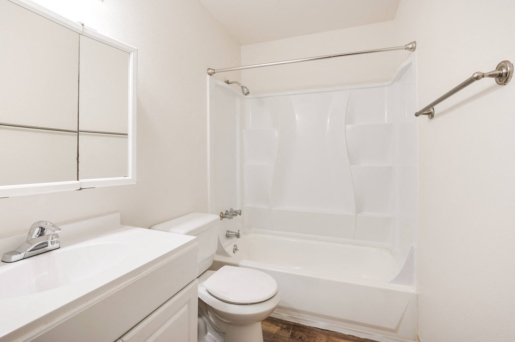 a bathroom with a toilet sink and tub and a mirror