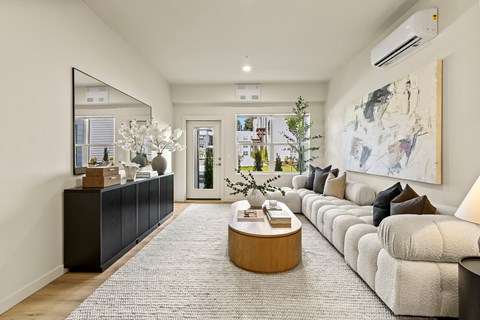 A modern living room with a large mirror, a coffee table, and a large painting on the wall.