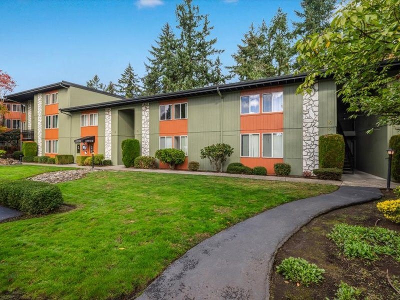 an apartment building with a green and orange facade and a winding sidewalk