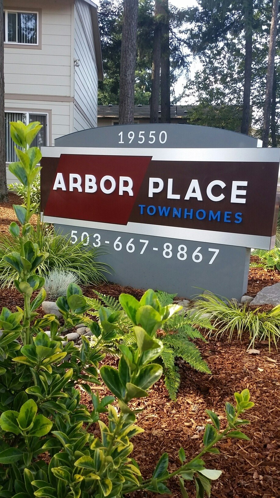 A sign for Arbor Place Townhomes with a phone number on it.