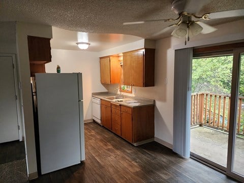 an empty kitchen with wooden cabinets and a sliding glass door