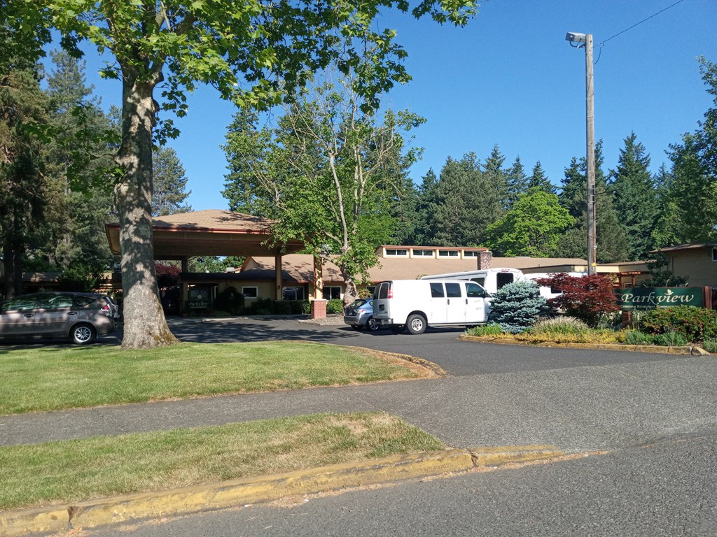 an parked in front of a building with trees