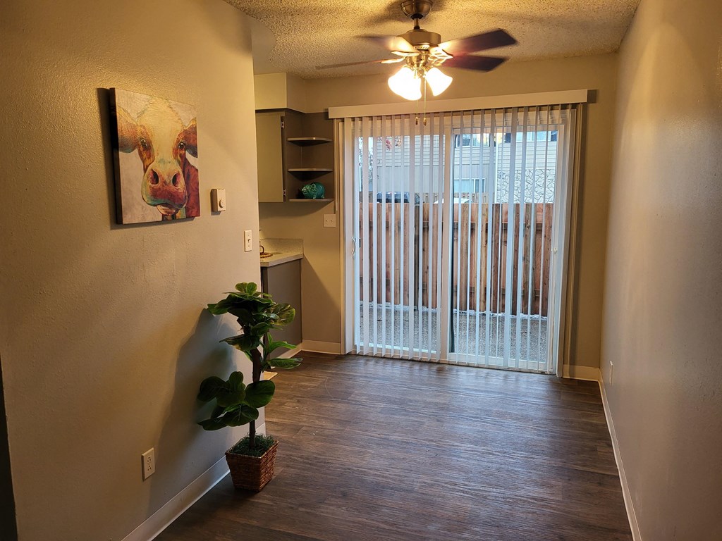 a living room with a sliding glass door and a ceiling fan