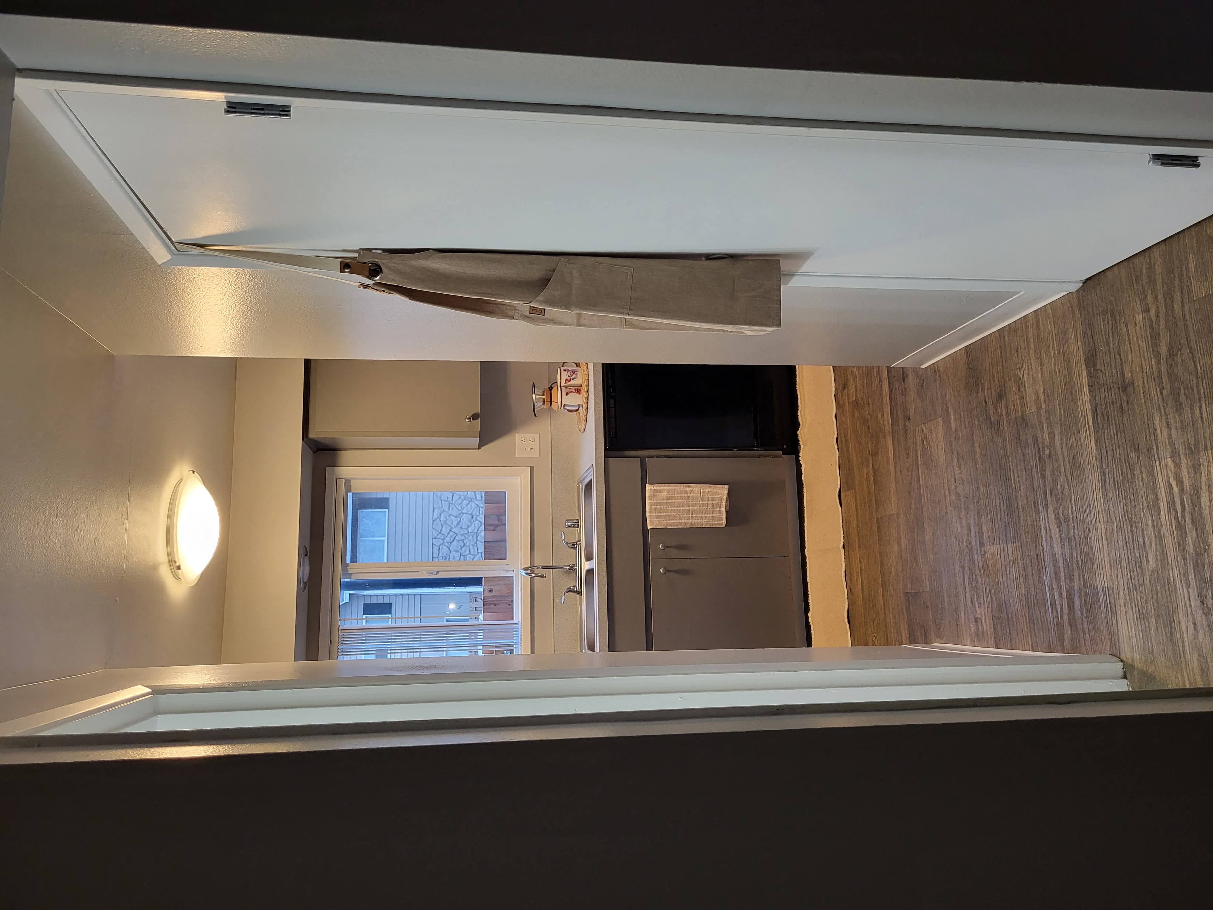 an empty room with a bath tub and a refrigerator in it