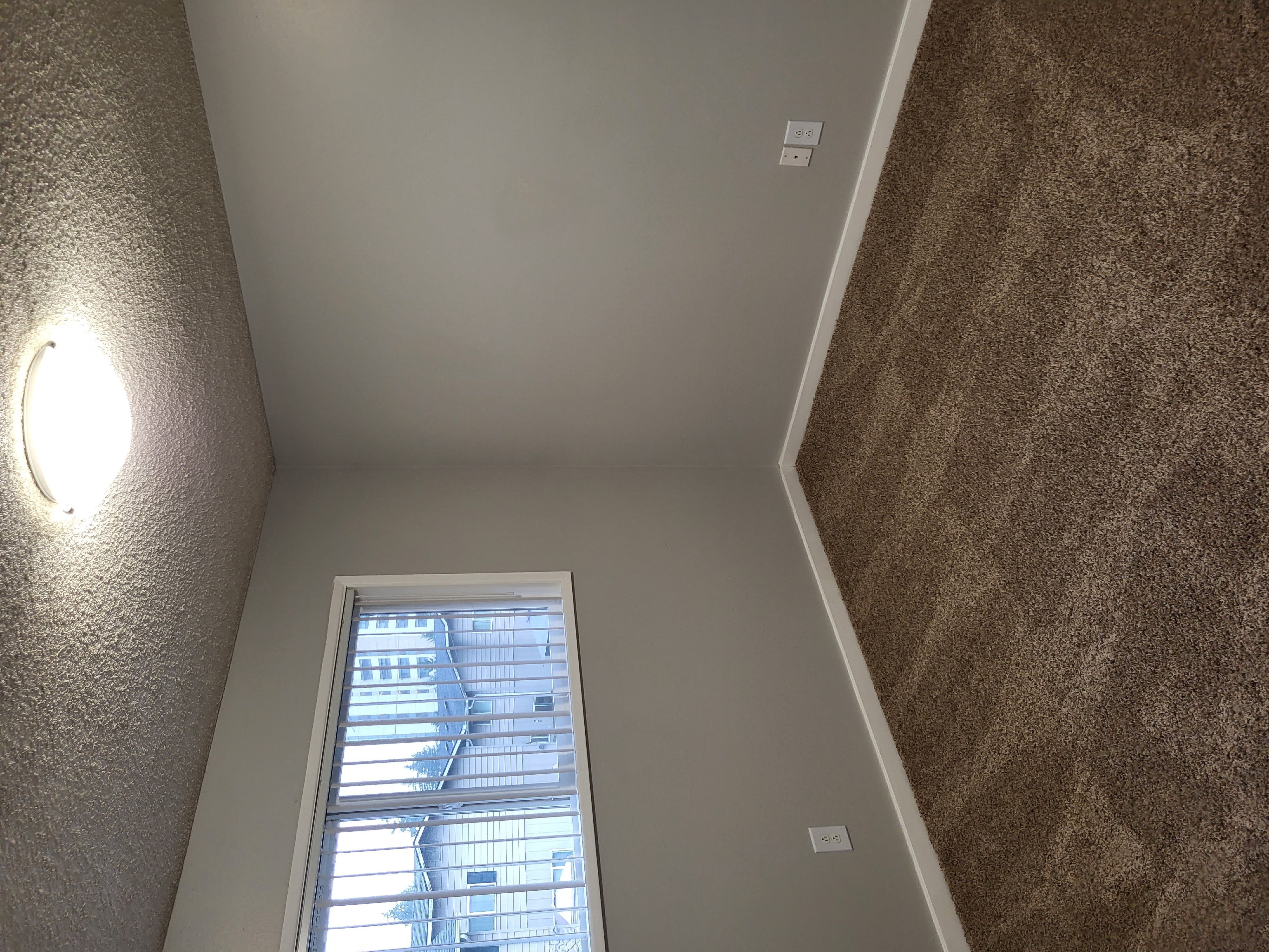 the view from the bottom of a staircase looking up at a window
