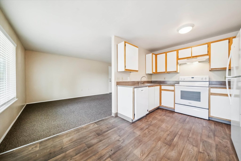 A kitchen with white cabinets and a white oven.