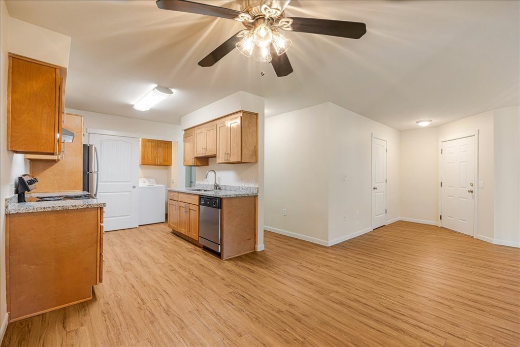 Cascade Woods living area with kitchen and ceiling fan in view