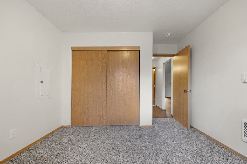 a bedroom with white walls and a carpeted floor