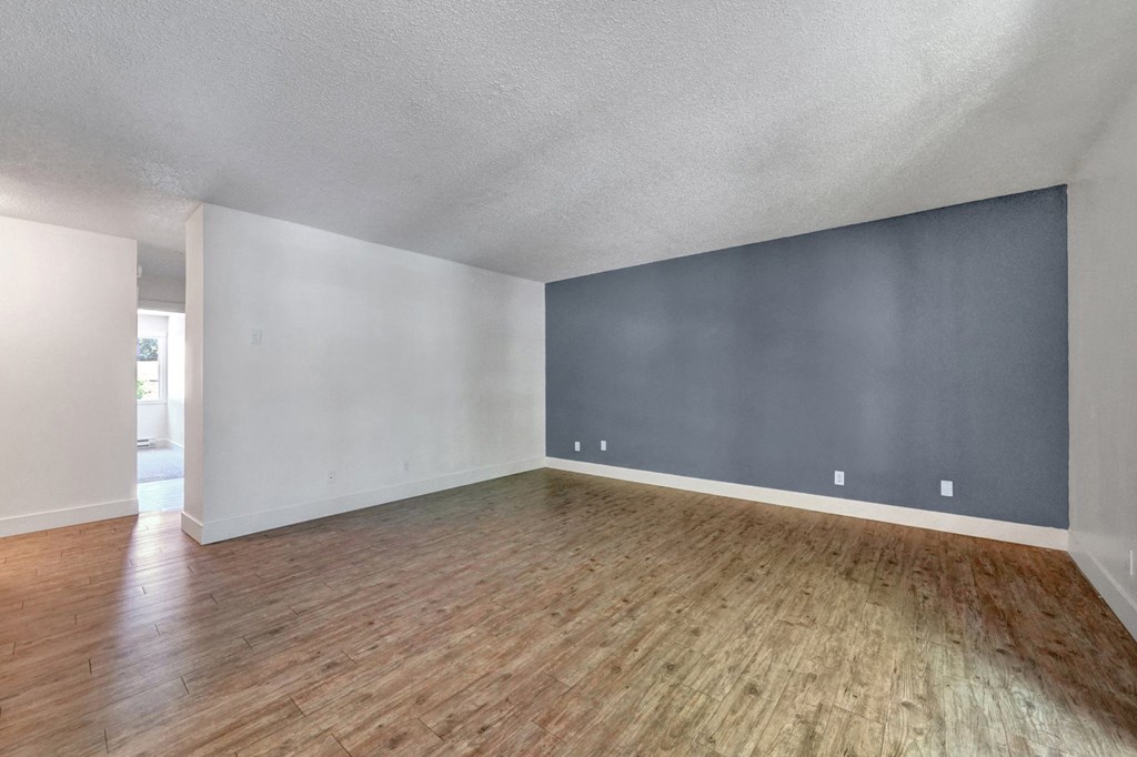 a bedroom with hardwood floors and grey walls