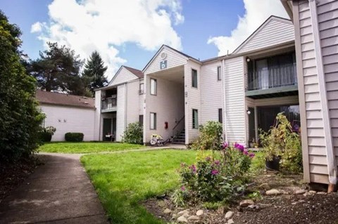 A sunny day at a residential building with a well-kept garden in front.