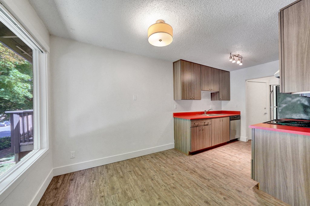 a kitchen with red countertops and wooden cabinets