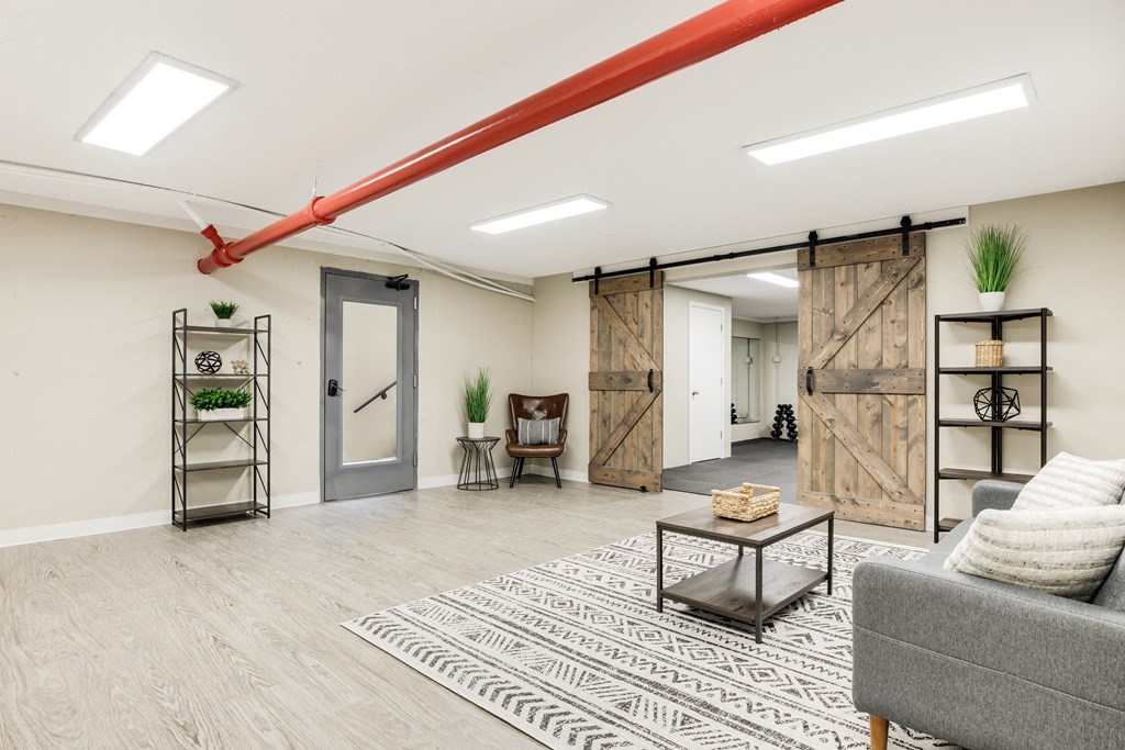a living room with a couch and a table in front of a sliding barn door