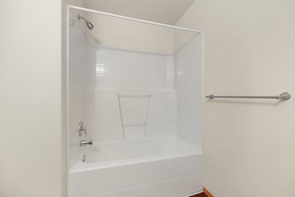 a bathroom with a bathtub and a towel rack