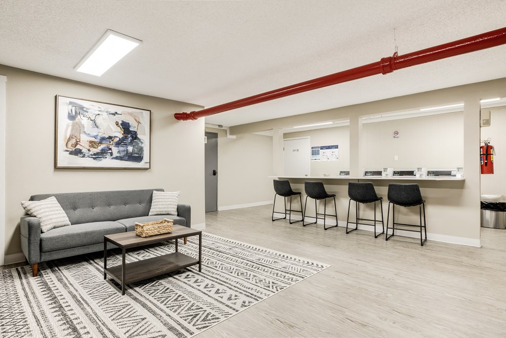 a living room with a couch and a coffee table and a bar with chairs