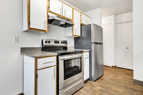 a kitchen with white cabinets and stainless steel appliances