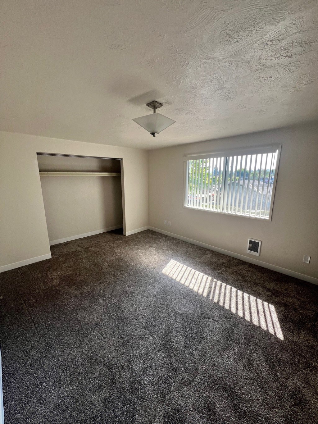 A room with a window and a ceiling fan.