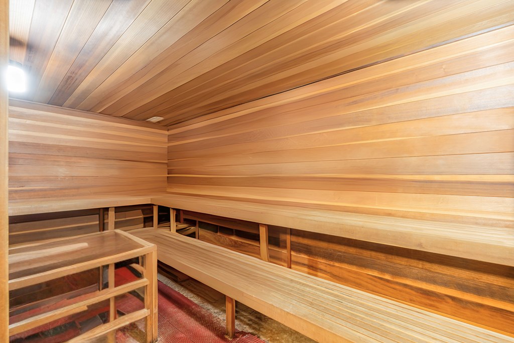 A wooden sauna with benches and a table.