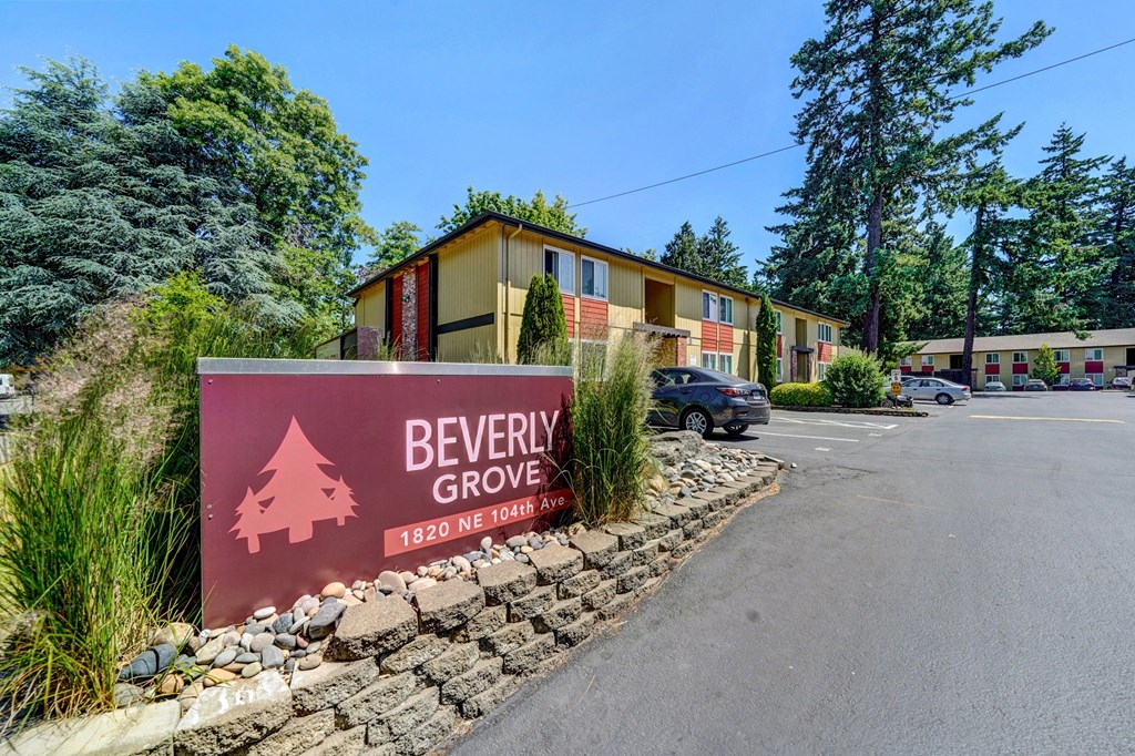 a red sign with the words beverly grove is in front of a yellow building