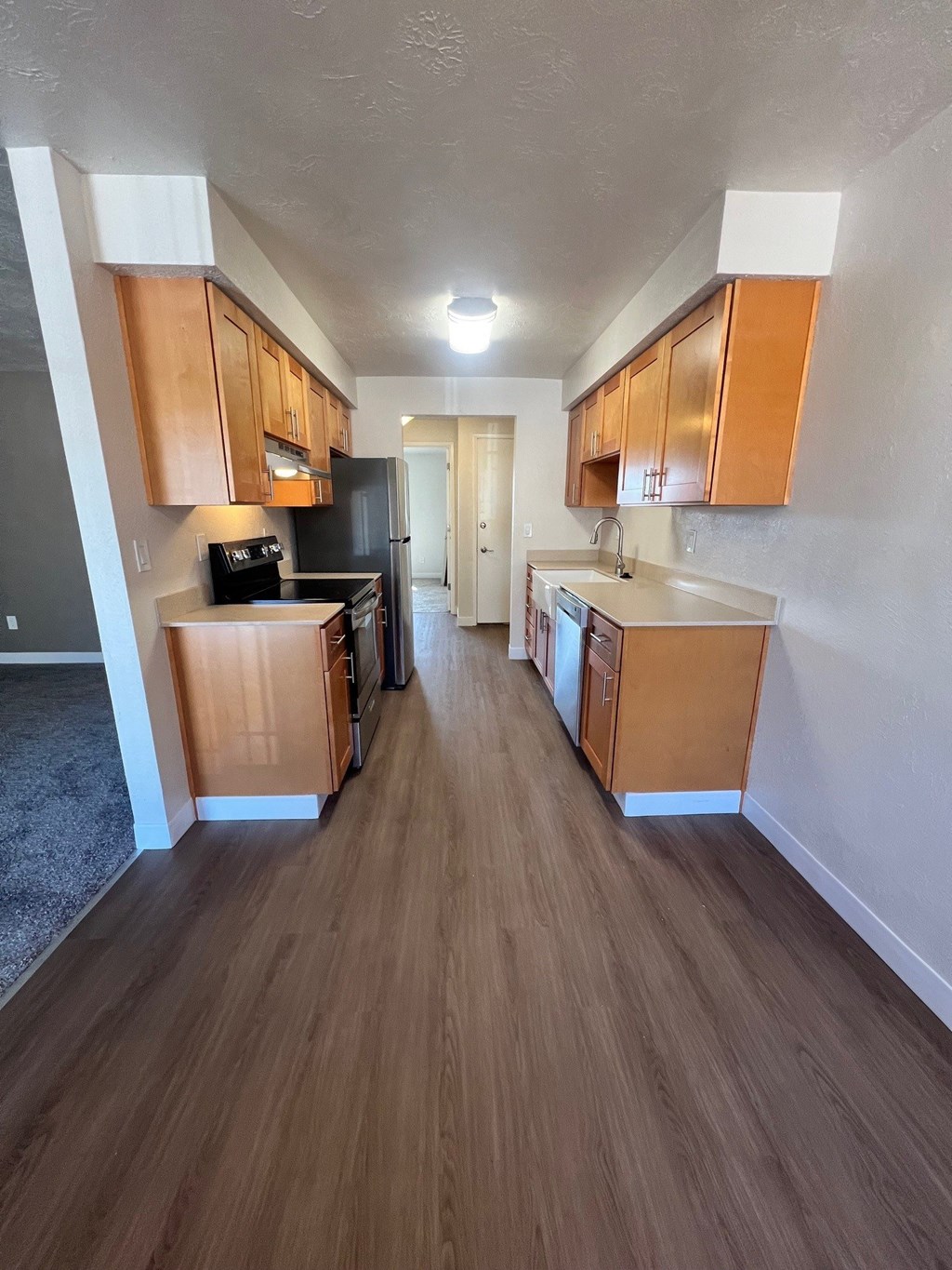 A kitchen with wooden cabinets and a black refrigerator.