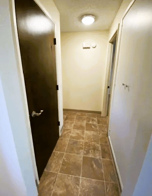 Nell Anna Court hallway with a black door and tiled floor.
