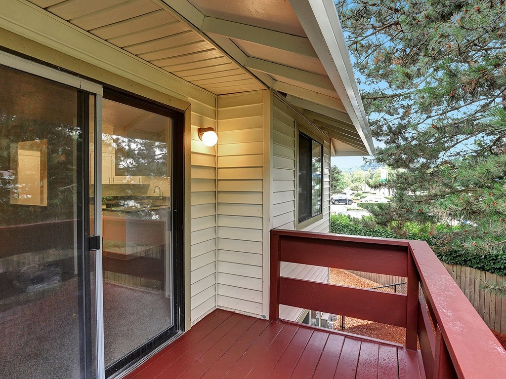a deck with a red railing and a sliding glass door Foothills Apartments Portland OR 