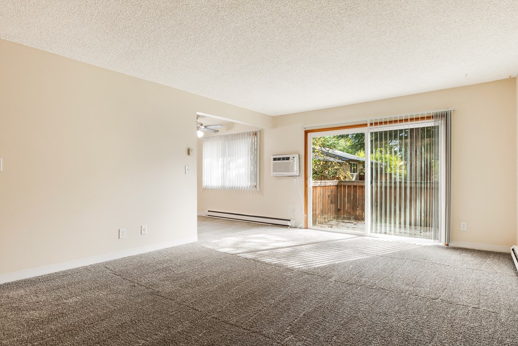 an empty living room with a sliding glass door to a patio