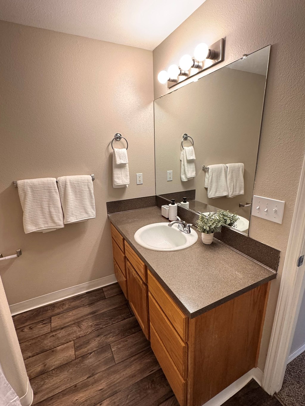 A bathroom with a sink, mirror, and towel rack.