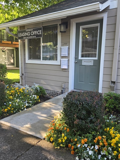 A small building with a green door and a sign that says "Leasing Office".