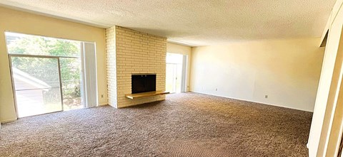 A living room with a television and sliding glass doors.