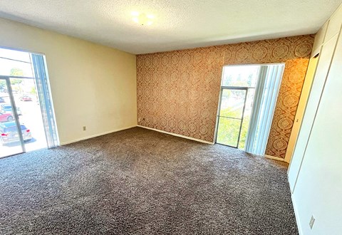 A room with a carpeted floor and patterned wallpaper.