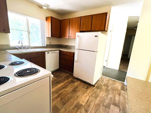 A kitchen with a white fridge and a white stove top.
