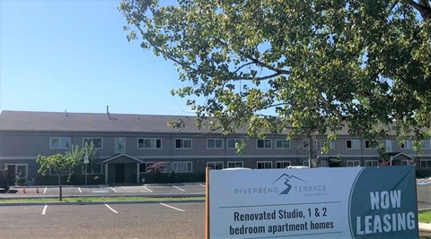 A sign in front of a building advertises leasing for renovated studio and 1 & 2 bedroom apartment homes.