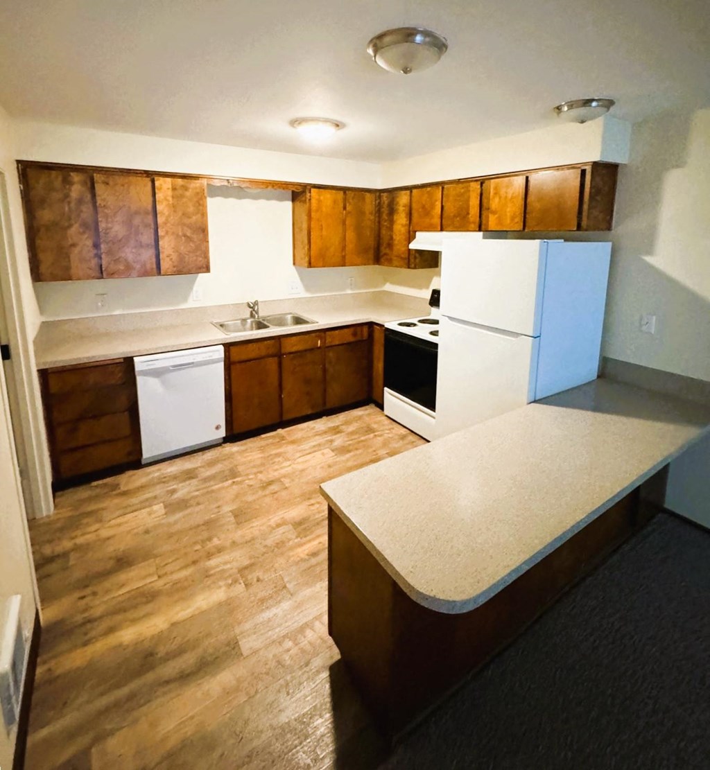 A kitchen with wooden cabinets and a white fridge.